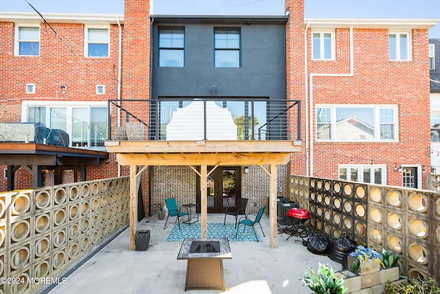 rear view of house featuring a patio and a fire pit