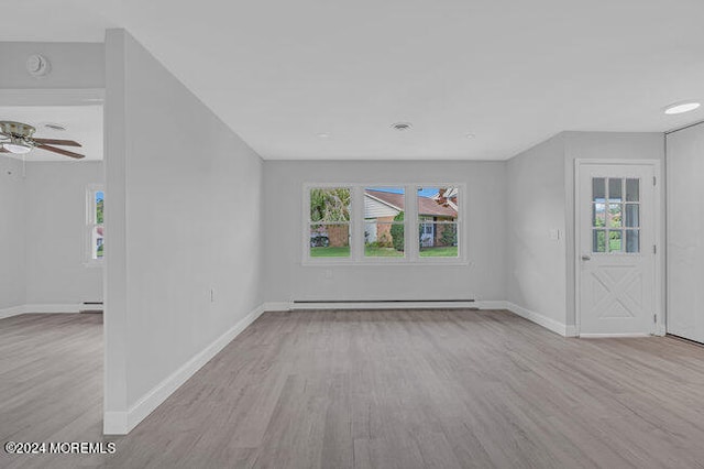 unfurnished living room featuring baseboard heating, light hardwood / wood-style flooring, and ceiling fan