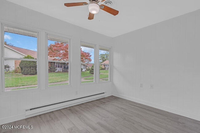 empty room featuring a baseboard radiator, light wood-type flooring, and ceiling fan