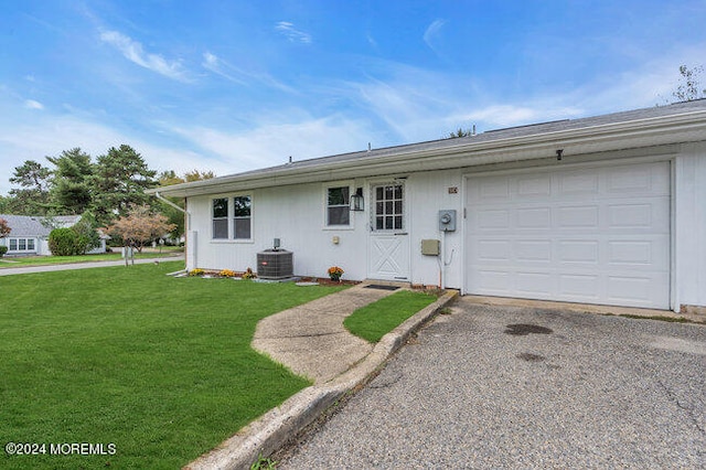 ranch-style home with cooling unit, a front yard, and a garage