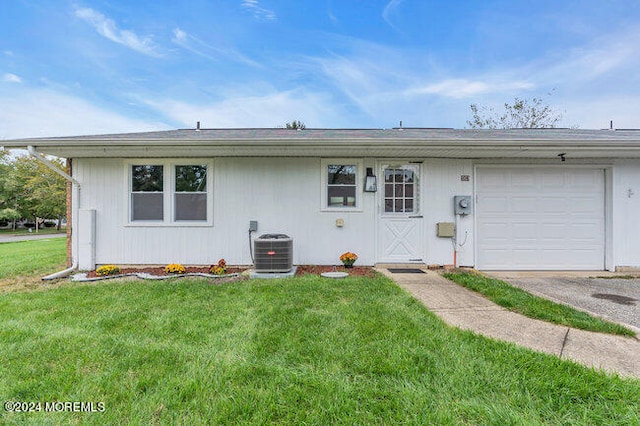 single story home featuring a garage, central air condition unit, and a front yard