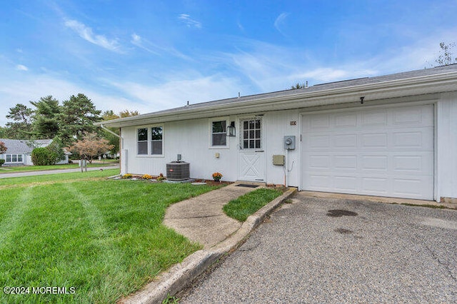 ranch-style house with a garage, a front lawn, and central AC