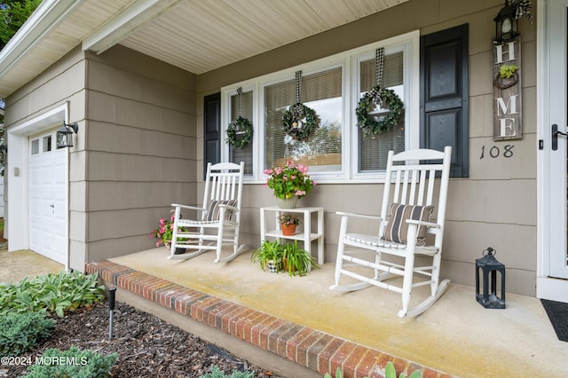 entrance to property featuring a porch and a garage