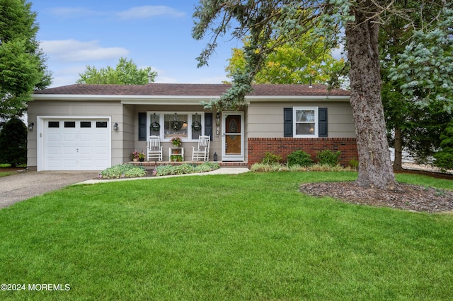 ranch-style home with a garage, covered porch, and a front yard