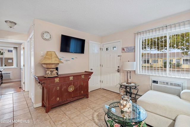 tiled living room featuring a textured ceiling and a wall mounted air conditioner