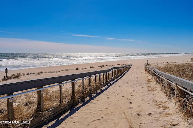 surrounding community featuring a water view and a view of the beach