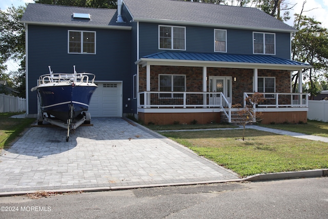 view of front facade featuring a porch, a garage, and a front yard