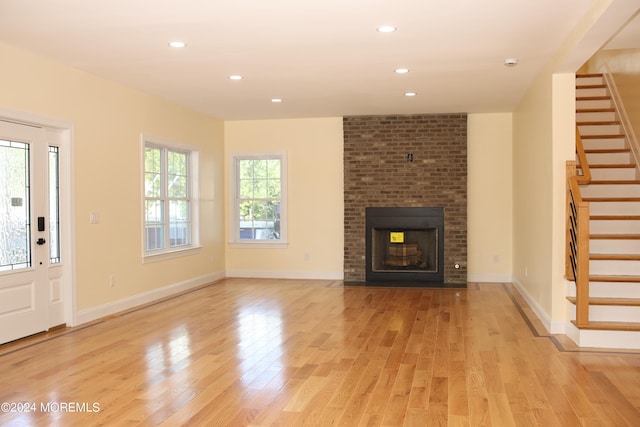 unfurnished living room with light wood-type flooring and a fireplace