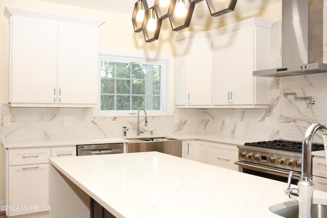 kitchen featuring light stone counters, white cabinets, backsplash, and wall chimney range hood