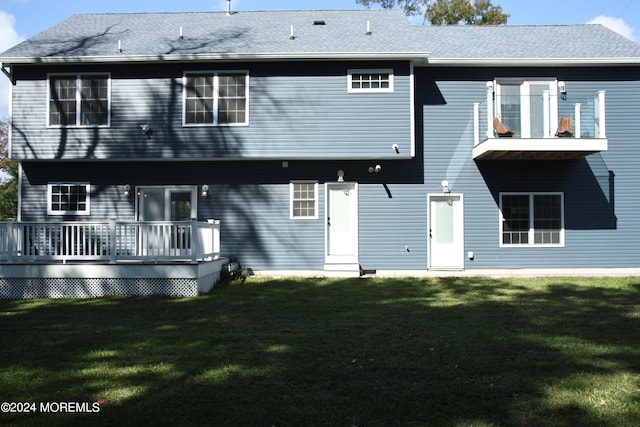 back of property featuring a deck and a yard