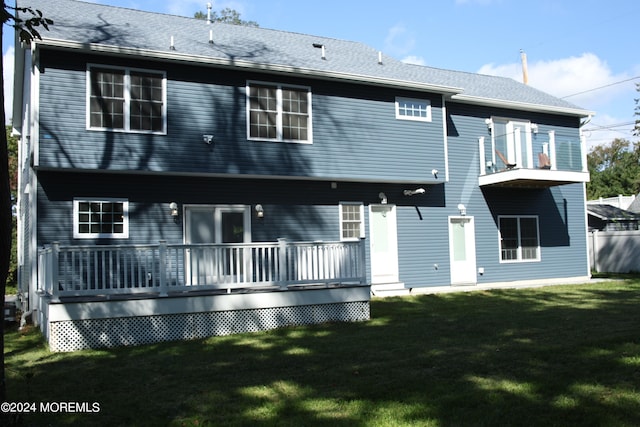 back of property featuring a lawn, a wooden deck, and a balcony