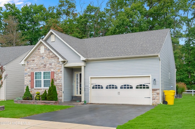 view of front of home with a front yard and a garage