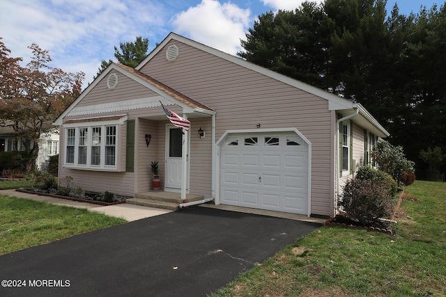 view of front of house with a garage and a front lawn