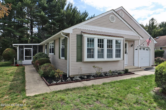 view of front of house featuring a front yard, a garage, and a sunroom