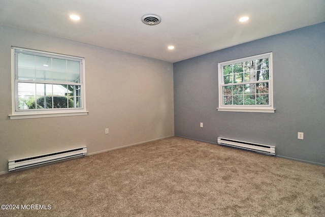 unfurnished room with carpet floors and baseboard heating