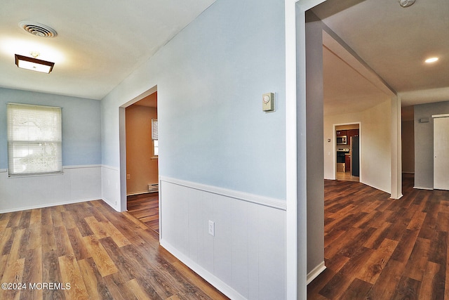 hall with baseboard heating and dark hardwood / wood-style floors