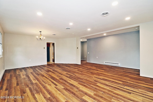 unfurnished room with wood-type flooring, an inviting chandelier, and a baseboard radiator