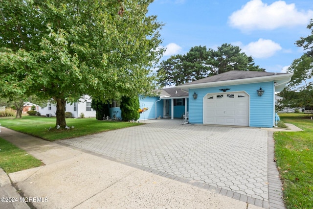 view of front of property with a front yard and a garage