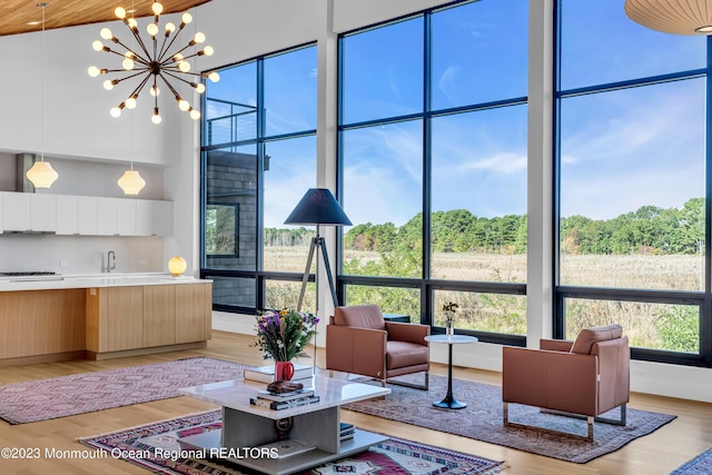 49 N Cherokee Ln, Brick, NJ 08724 - living area with a towering ceiling, light wood-style floors, expansive windows, and a chandelier