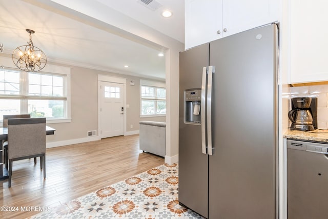 kitchen featuring light stone counters, white cabinets, pendant lighting, stainless steel appliances, and light wood-type flooring