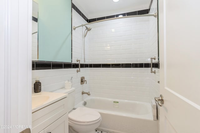 full bathroom with tile walls, backsplash, vanity, tiled shower / bath, and toilet