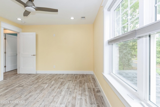 spare room with light wood-type flooring and ceiling fan