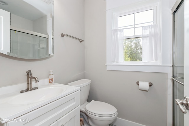 bathroom with walk in shower, vanity, and toilet