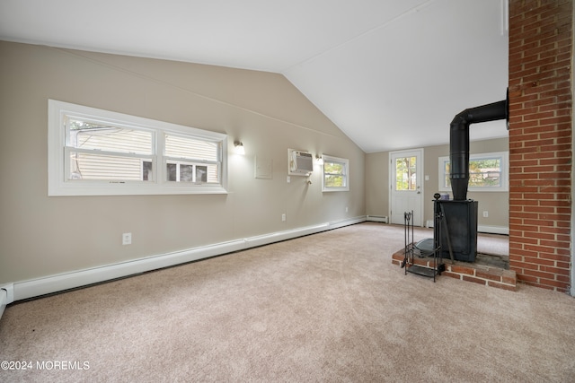 unfurnished living room with vaulted ceiling, a wall mounted air conditioner, a wood stove, a baseboard heating unit, and light colored carpet