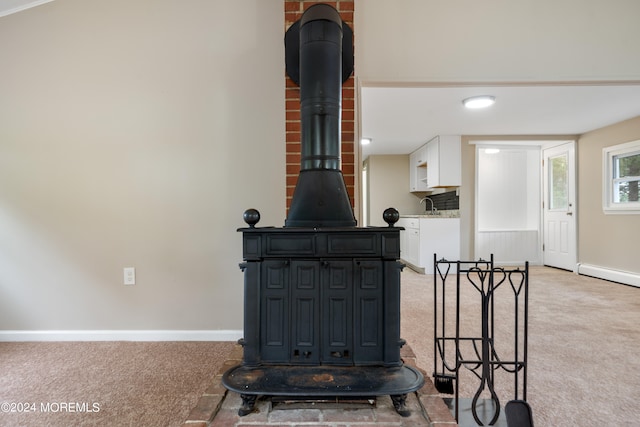 details featuring a wood stove, carpet floors, and sink