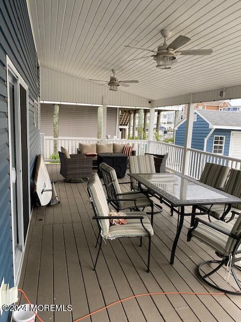 wooden deck featuring outdoor lounge area and ceiling fan