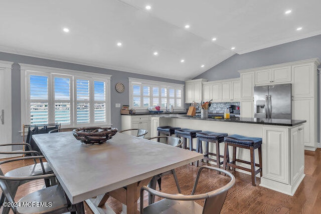 dining room with lofted ceiling, crown molding, and dark hardwood / wood-style flooring