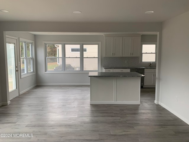 kitchen with decorative backsplash, wood-type flooring, dishwasher, and sink