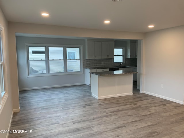 kitchen with light hardwood / wood-style flooring, plenty of natural light, and decorative backsplash