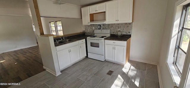 kitchen with white cabinets, backsplash, white electric range oven, hardwood / wood-style floors, and sink