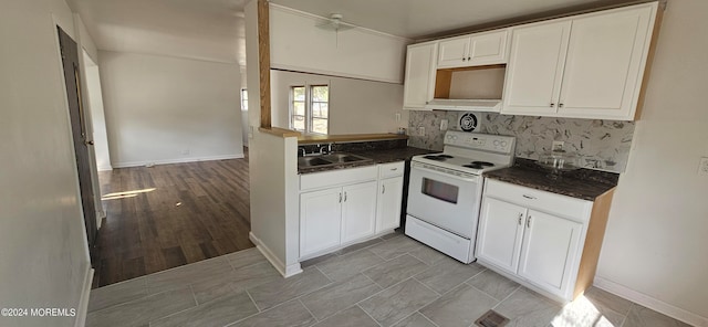 kitchen with decorative backsplash, light hardwood / wood-style floors, white cabinets, white range with electric cooktop, and sink