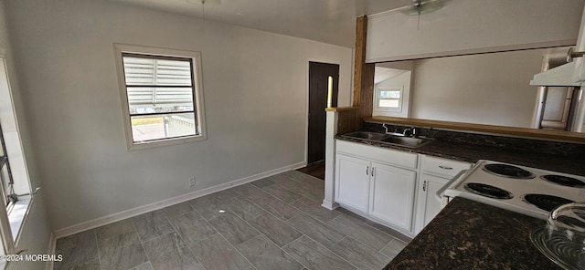 kitchen featuring ceiling fan, sink, white cabinetry, white electric range, and dark stone countertops