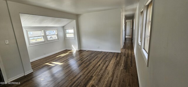 spare room with vaulted ceiling and dark wood-type flooring