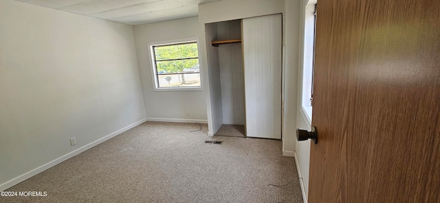 unfurnished bedroom featuring light colored carpet and a closet