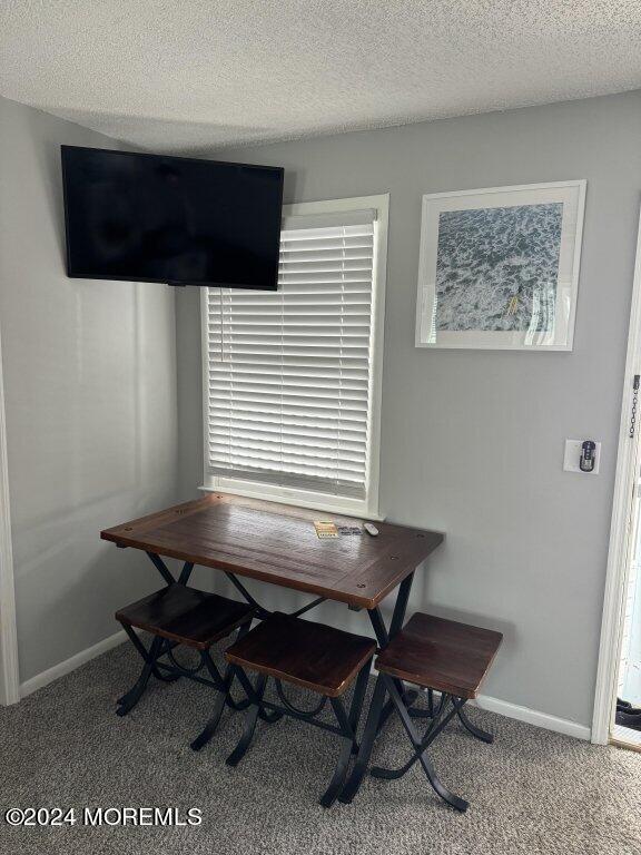 dining area with carpet and a textured ceiling