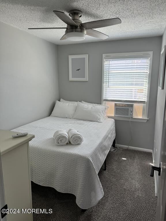 bedroom featuring cooling unit, ceiling fan, carpet floors, and a textured ceiling