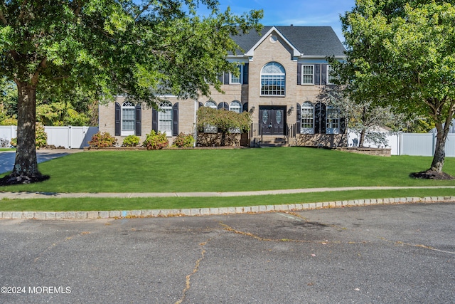 colonial-style house with a front lawn