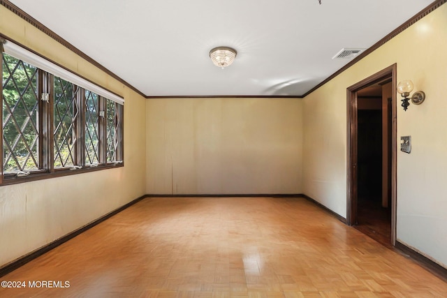 empty room featuring crown molding and light parquet flooring