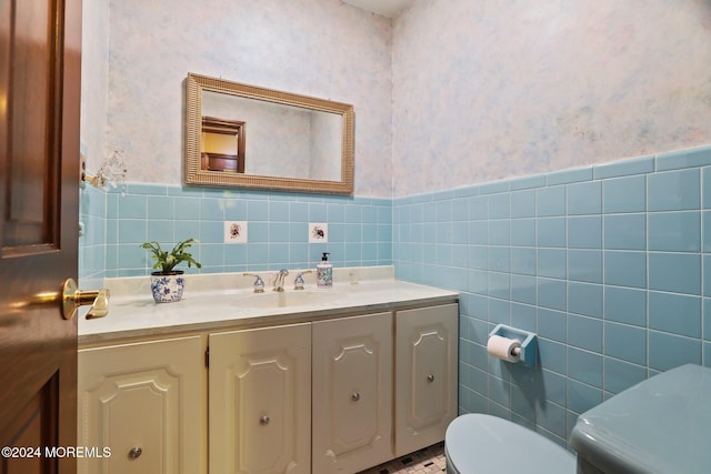 bathroom with vanity, tile walls, and toilet