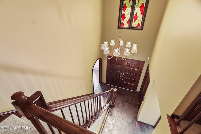 stairway featuring a notable chandelier