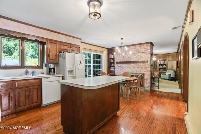 kitchen with a center island, dark hardwood / wood-style flooring, white appliances, and sink