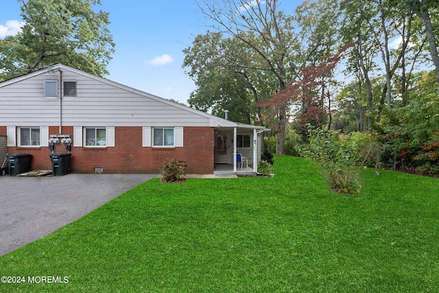 rear view of house with a yard and a patio area