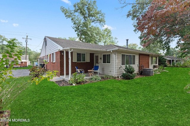 back of house with a patio, a yard, and central air condition unit