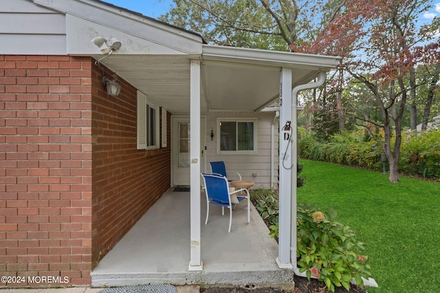 view of exterior entry with a yard