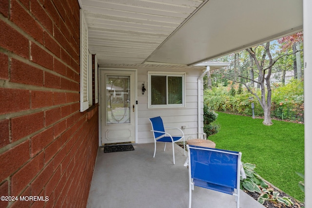 view of exterior entry featuring a patio and a yard