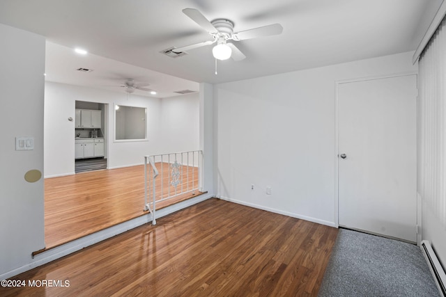 unfurnished room with wood-type flooring, baseboard heating, and ceiling fan